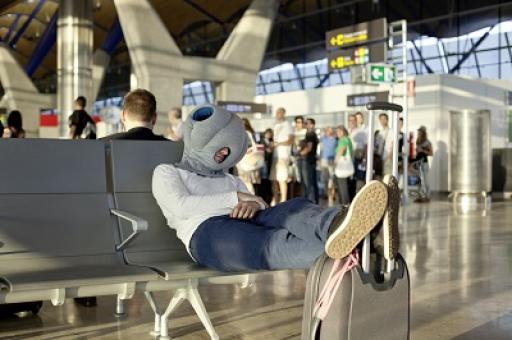 Ostrich Pillow Mann mit Ostrich Pillow am Flughafen